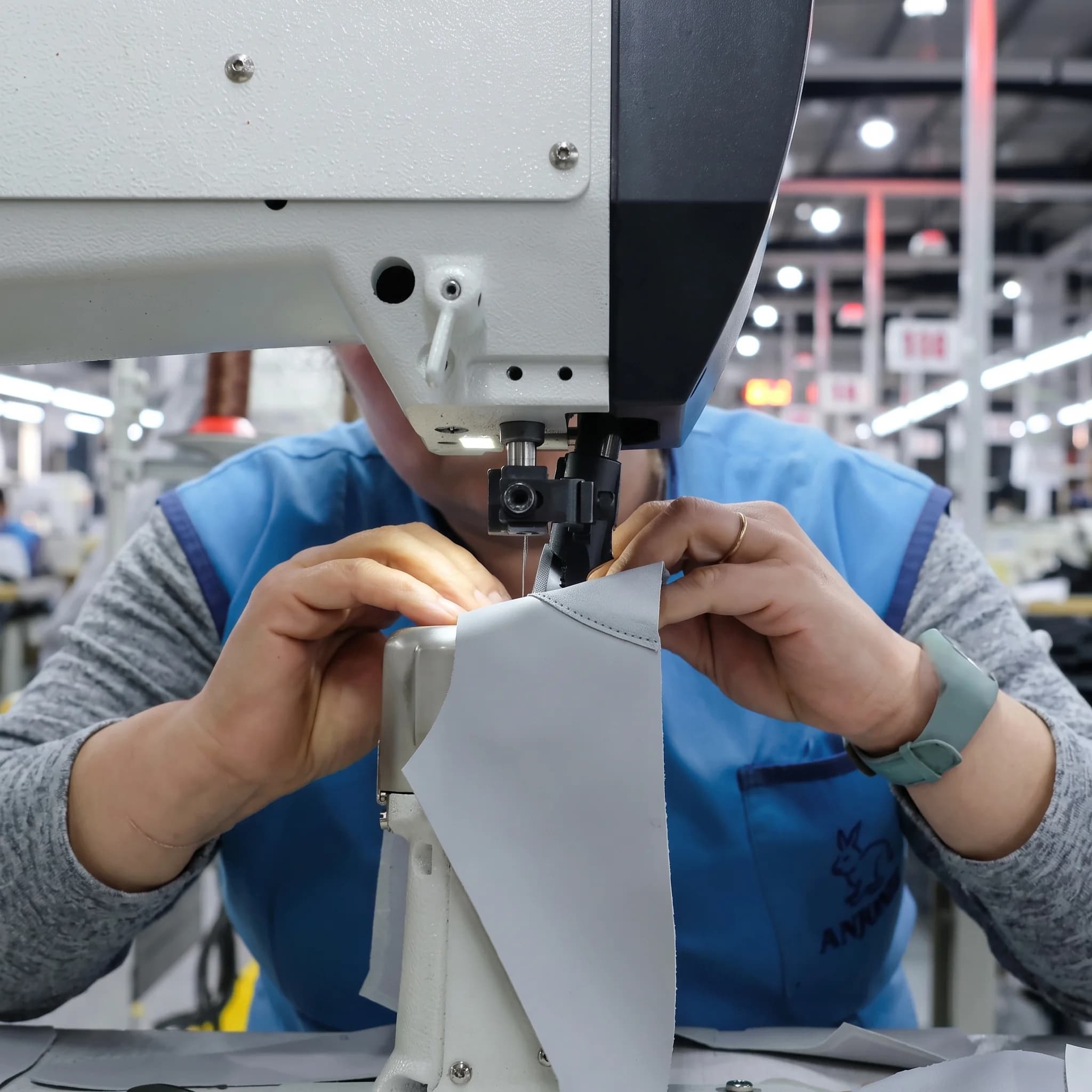 A workshop artisan stitching a shoe upper